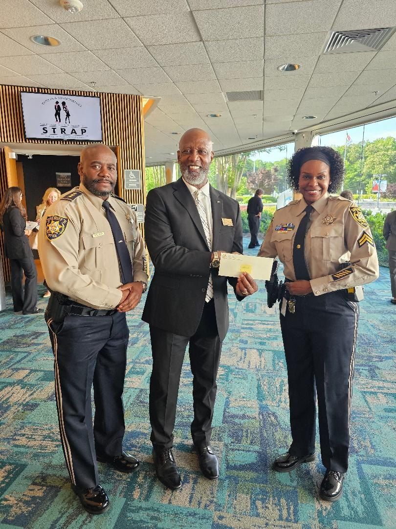 A STRAP representative with sheriff's officers during a community support donation.